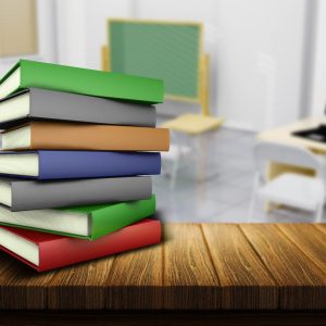 3D render of a wooden table and books with a defocussed classroom in the background
